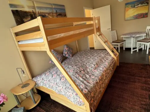 Etagenbett aus Holz im Schlafzimmer, daneben ein Beistelltisch