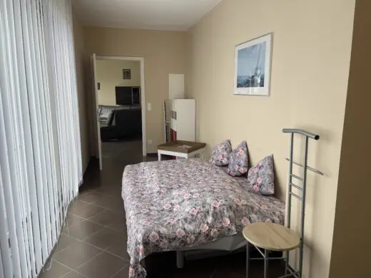 Durchgangszimmer mit Doppelbett, Blick zur Tür zum Wohn- und Essbereich
