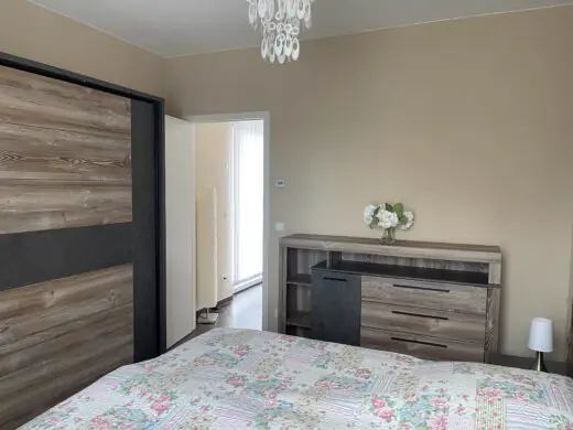 Schlafzimmer mit Schiebetürschrank und Kommode, Blick zur Tür
