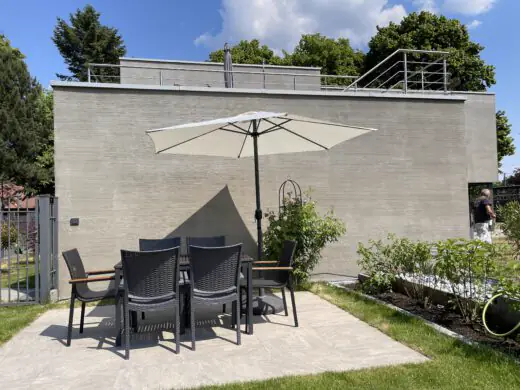 Gästegarten mit Gartentisch und Stühlen auf einer Terrassenplatte