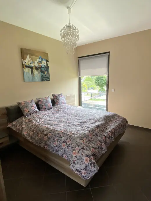 Schlafzimmer mit großem Doppelbett, Deckenlampe und Fenster
