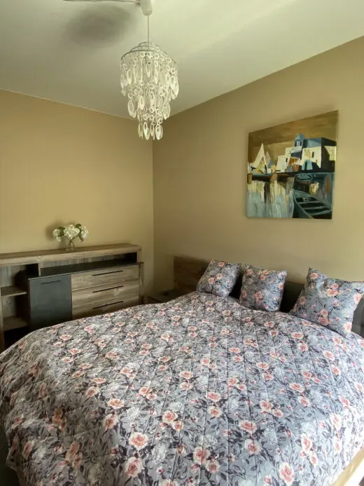 Schlafzimmer mit großem Doppelbett und Kommode