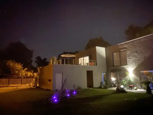 Haus und Garten bei Nacht, beleuchtet mit violetten Lichtern