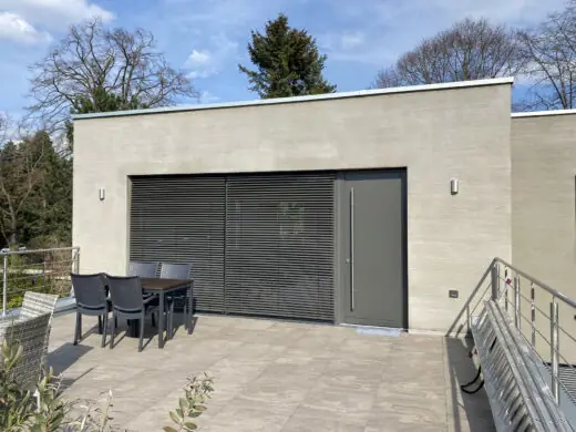 Dachterrasse mit Sitzgruppe vor dem Hauptgebäude mit geschlossenem Rollladen